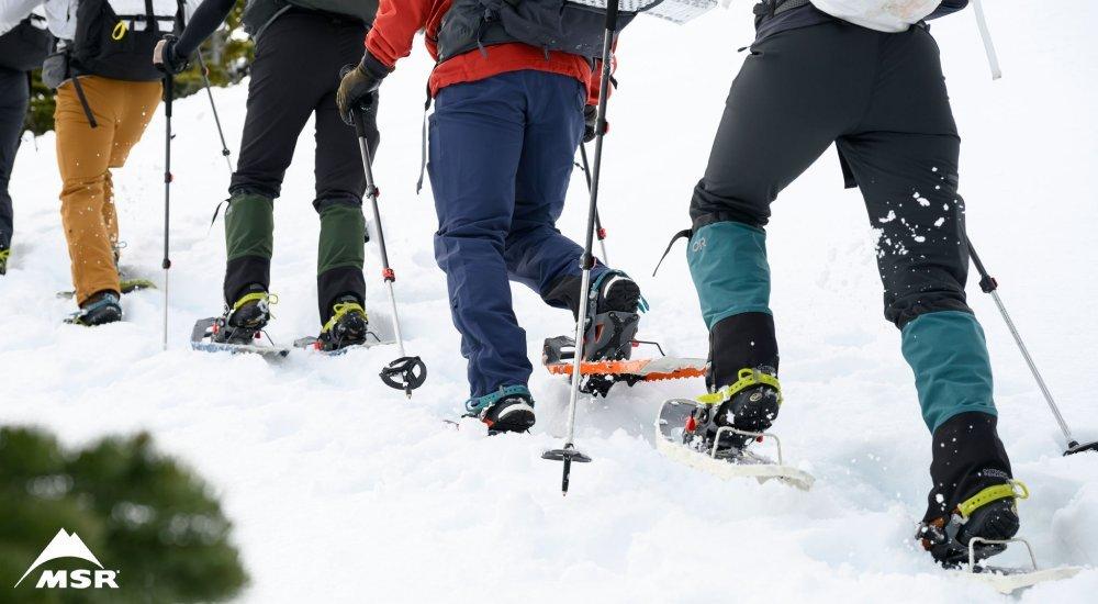 a group of people snowshoeing in a line