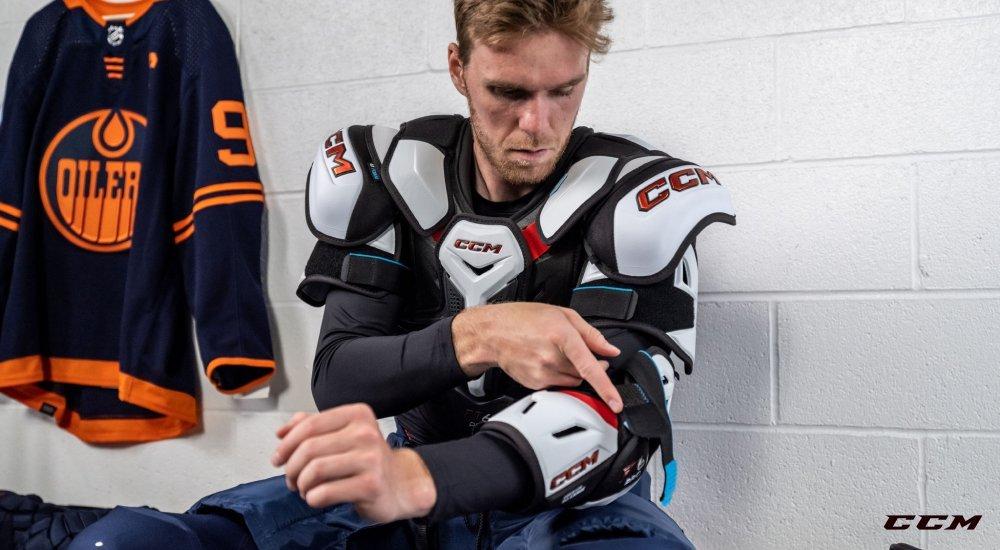 a hockey player strapping on his elbow pads