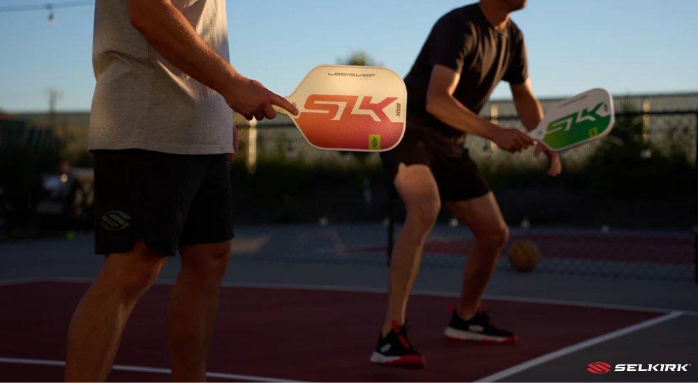 two pickleball players getting ready for the serve on the same side
