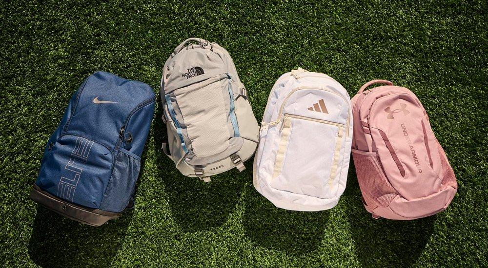 four branded backpacks on the grass