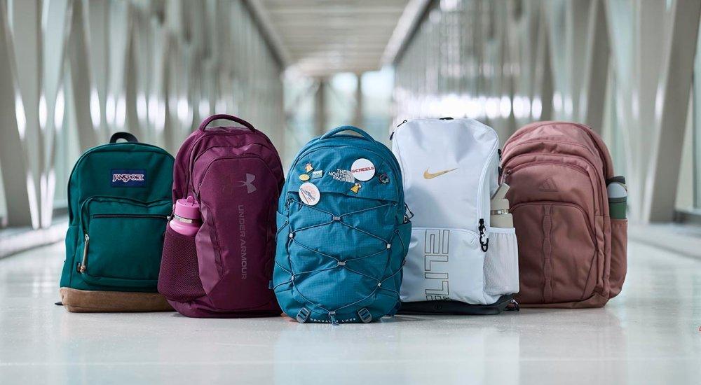 five backpacks lined up in a hallway