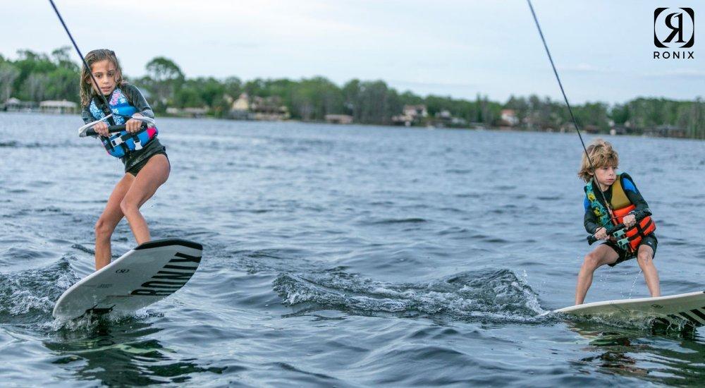 two kids wakeboarding on the lake