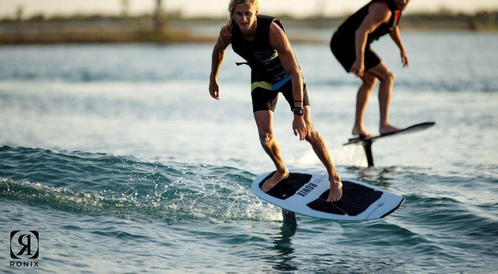 two people wakefoiling on the water