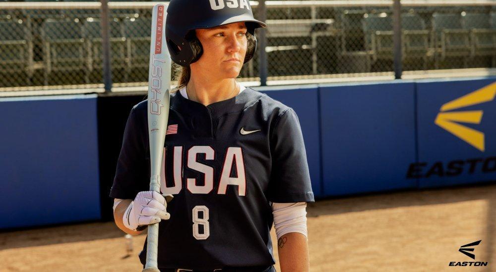 softball player on a softball field with a softball bat resting on her shoulder