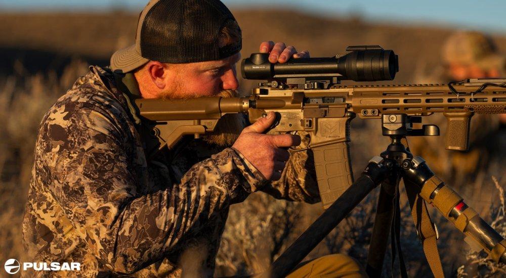 hunter looking through a Pulsar thermal riflescope on a rifle