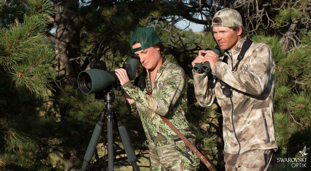 two people dressed in camo using Swarovski Optik