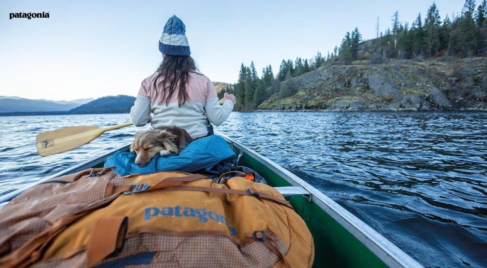 A woman paddles in a canoe with Patagonia gear