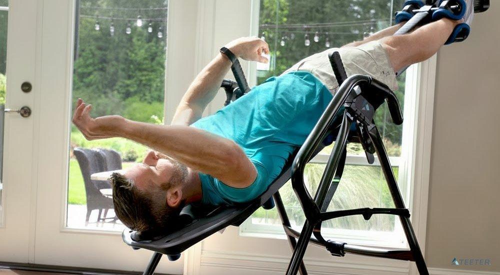 A man using a Teeter inversion table