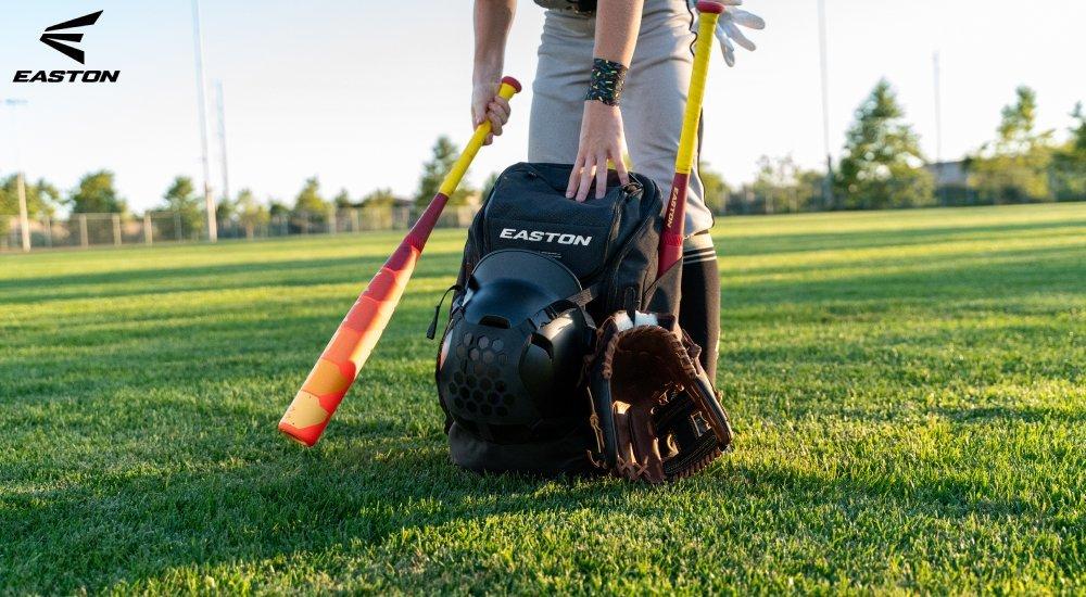 baseball player putting baseball bat into equipment bag