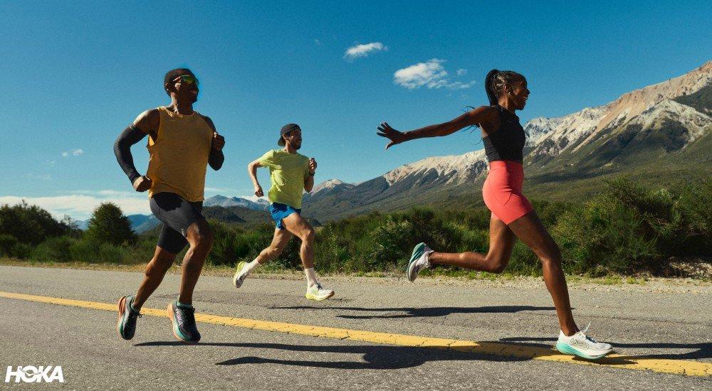 a group of three people running on the road in the desert