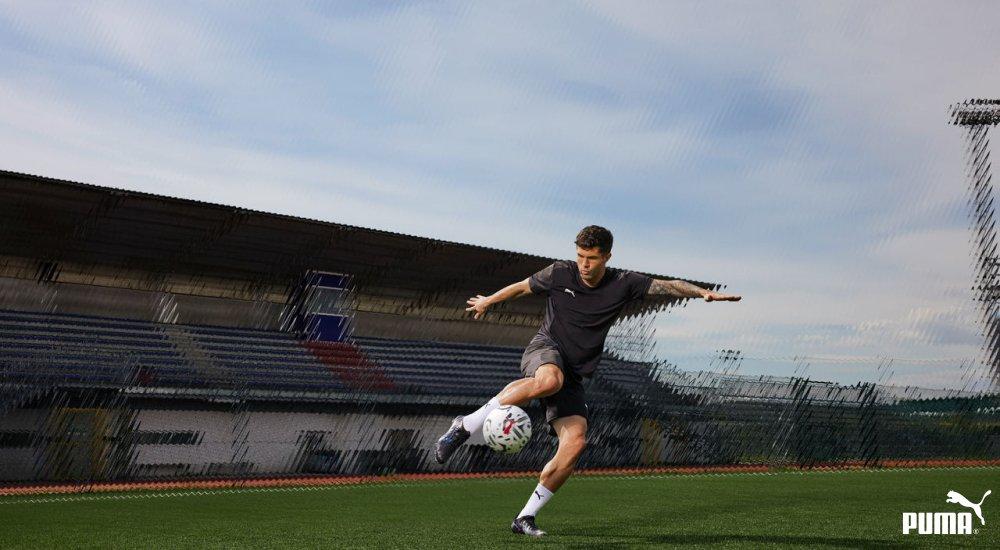 soccer player kicking a soccer ball wearing PUMA soccer cleats