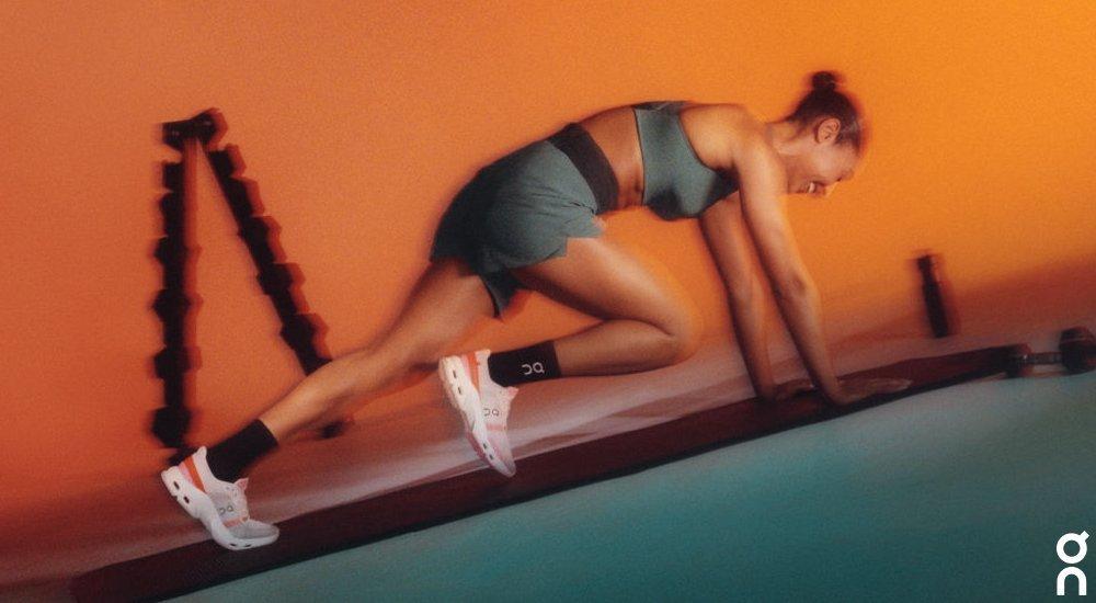 a woman doing mountain climber exercises in her on training shoes