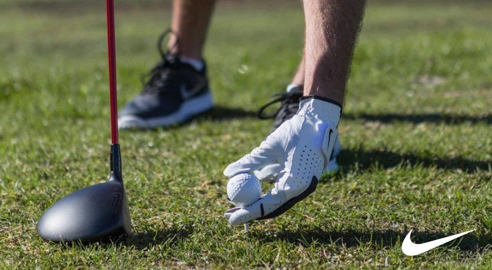 a golfer teeing up their golf ball