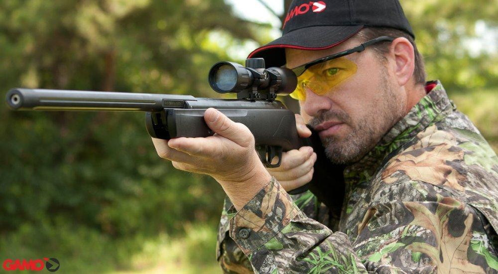 a man aiming to shoot a rifle