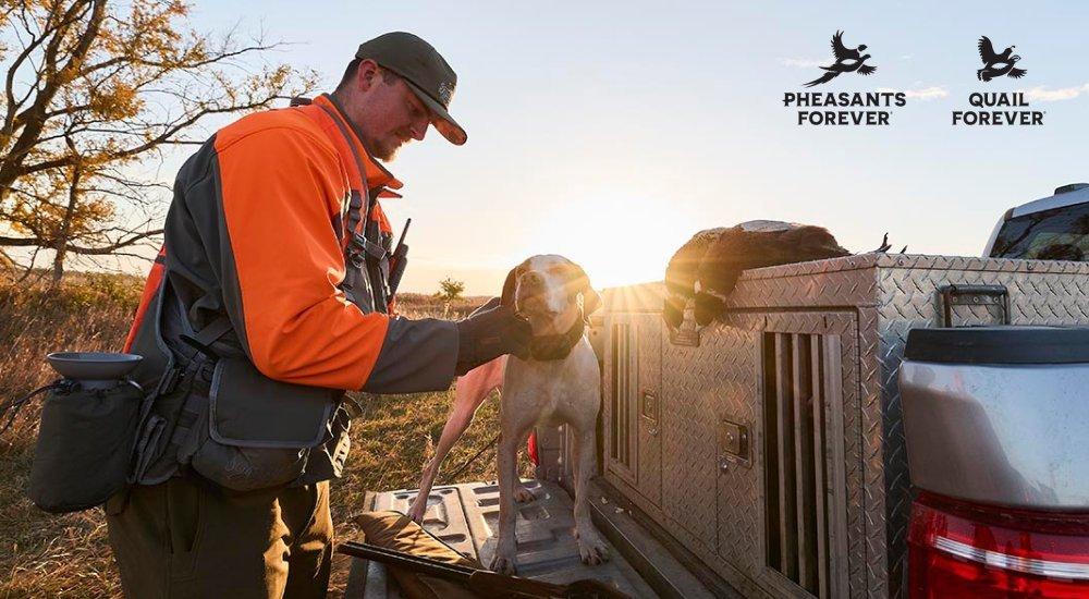 a woman walking through the field with her gun