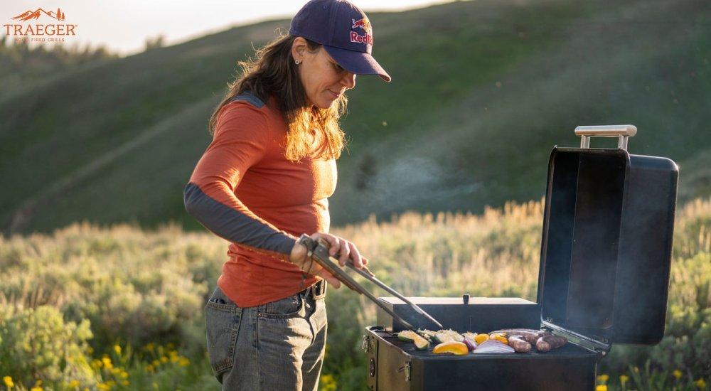 a woman grilling on her grill while at a campsite