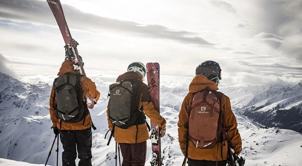 three skiers at the top of the mountain