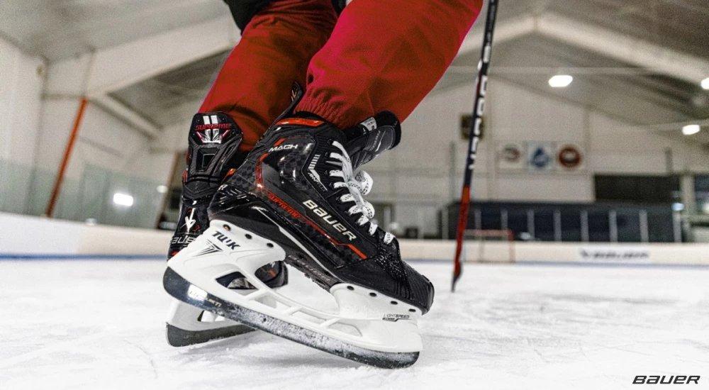 close up of a player with bauer hockey skates on the ice rink