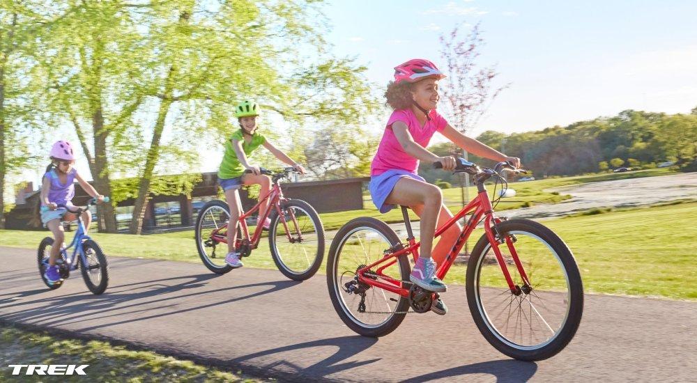 three kids riding bikes outside