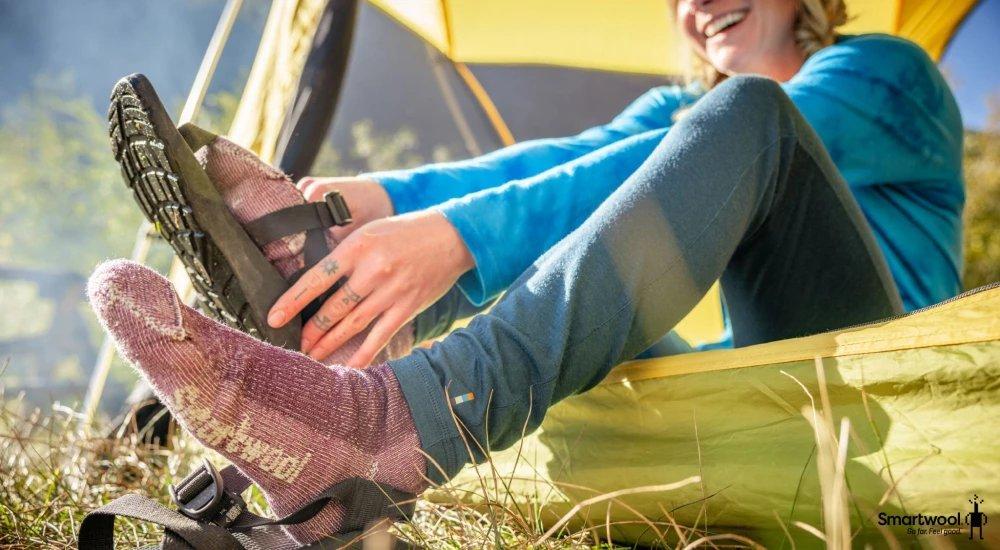 a camper putting on their chacos over their merino wool socks