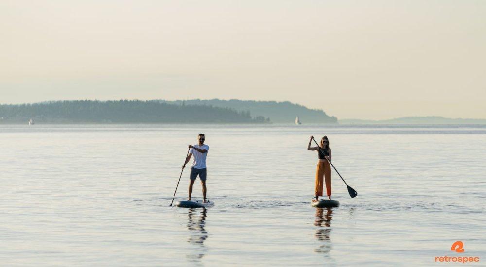 two people paddle boarding on the water