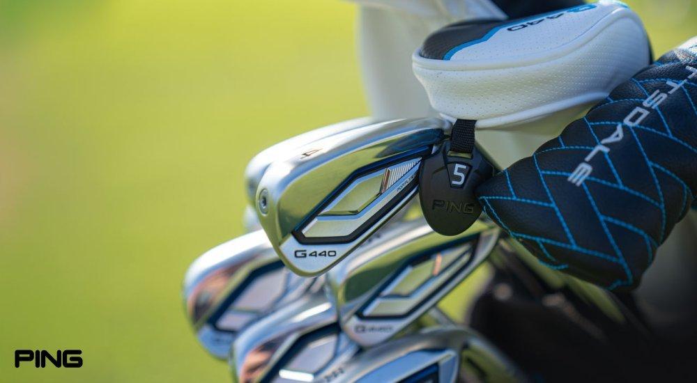 a selection of golf clubs in a bag on the golf course