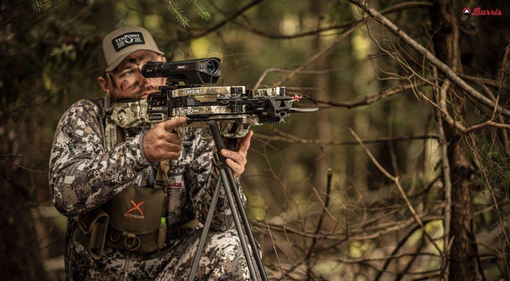 A hunter looks through a crossbow scope