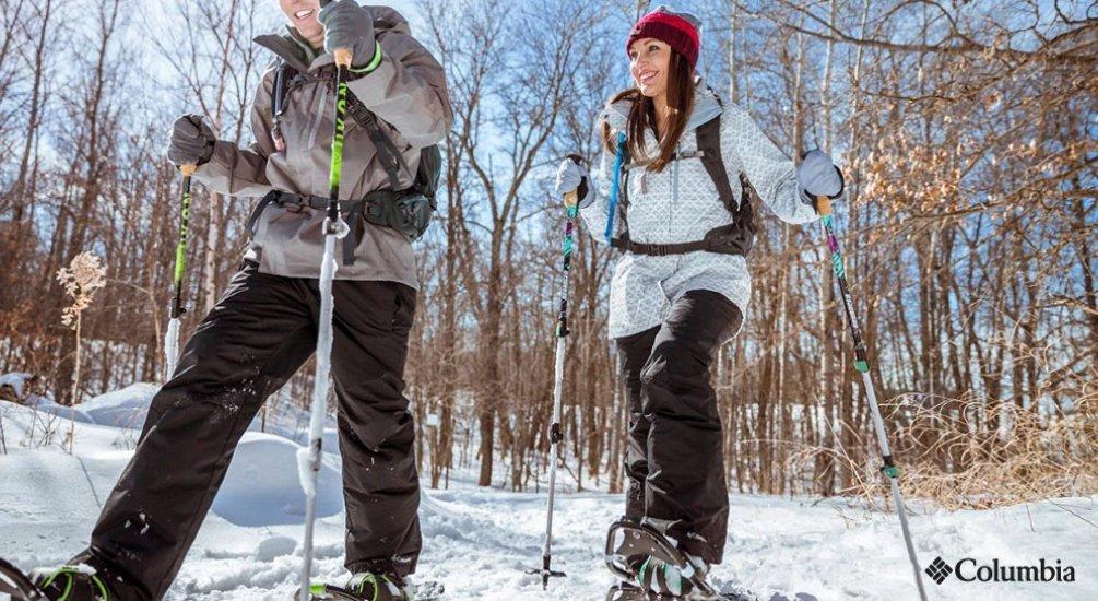 two people walking through the snow with their snow shoes