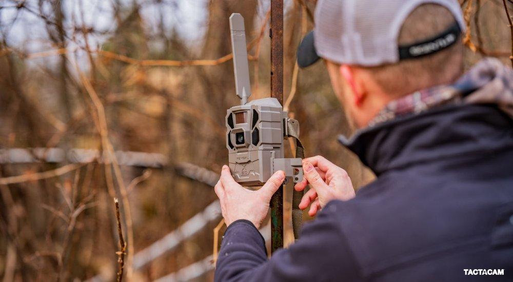 A man sets up a Tactacam trail cam on a tree
