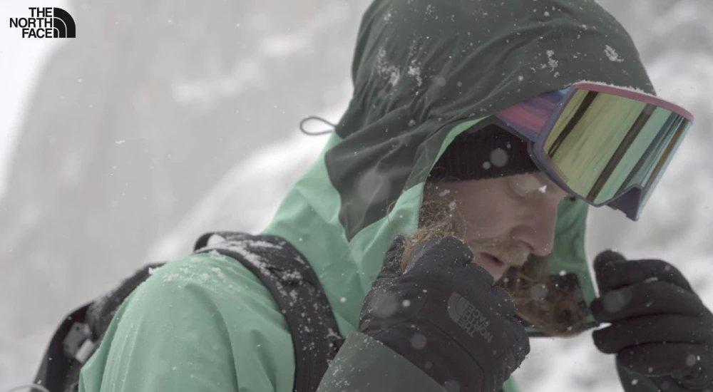 a man adjusting his north face hood on the slopes