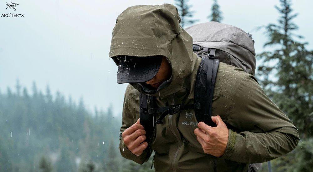 a man hiking in the rain with an arc'teryx jacket