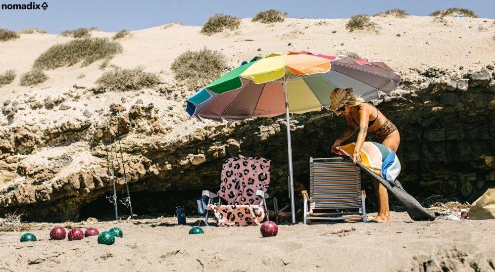 a woman setting up her beach camp for the day