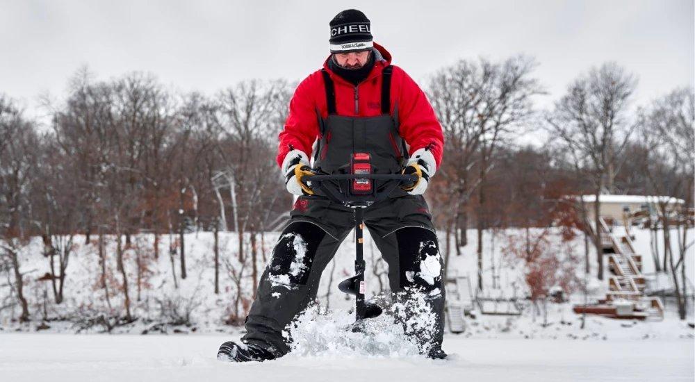 a man using an auger to cut a hole in the ice