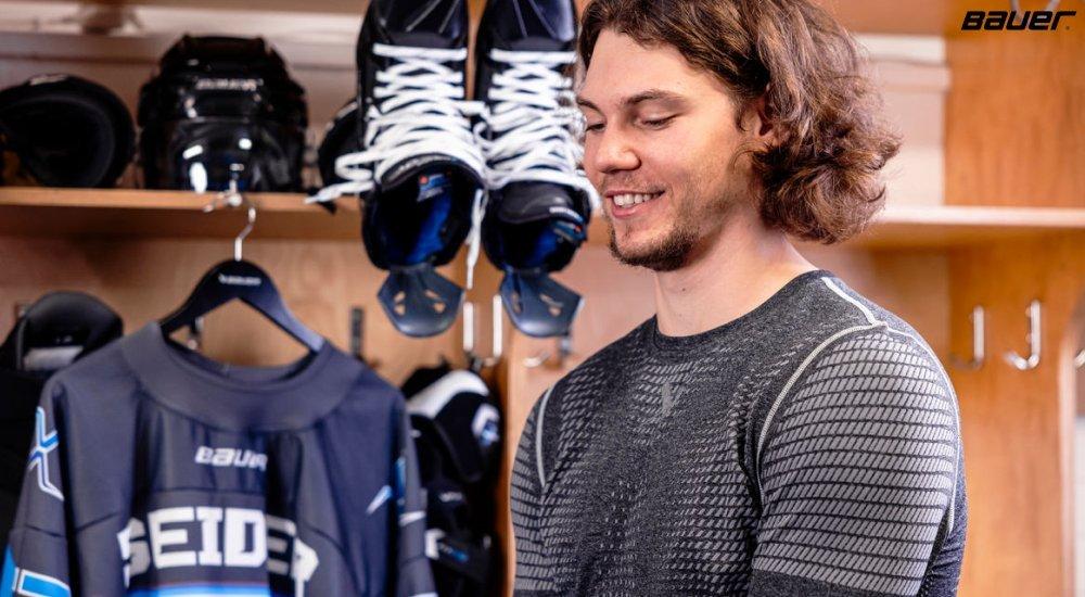 a hockey player with his base layers on ready to get on the rink