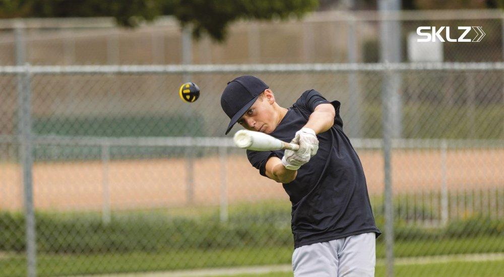 baseball player hitting the ball with a bat