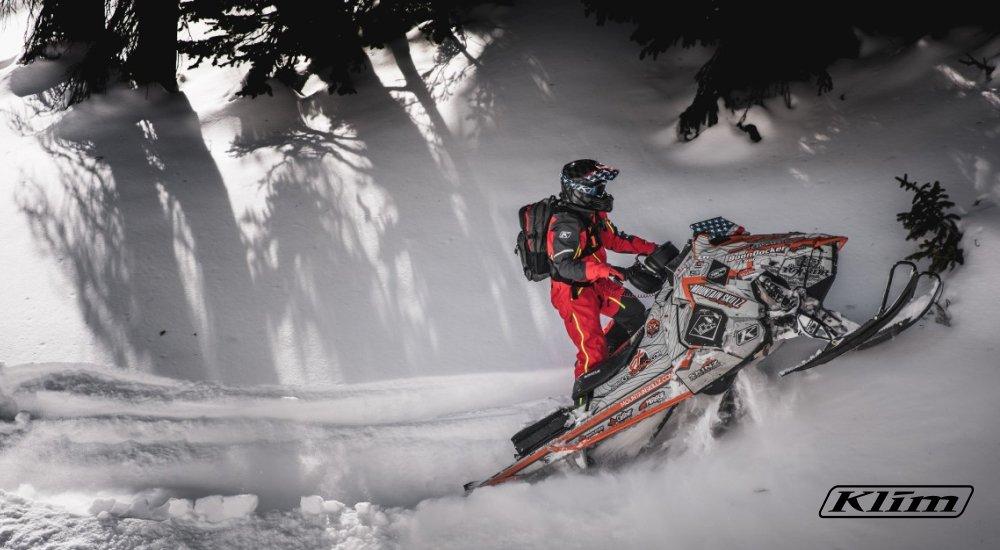 a person riding a snowmobile up a mountain