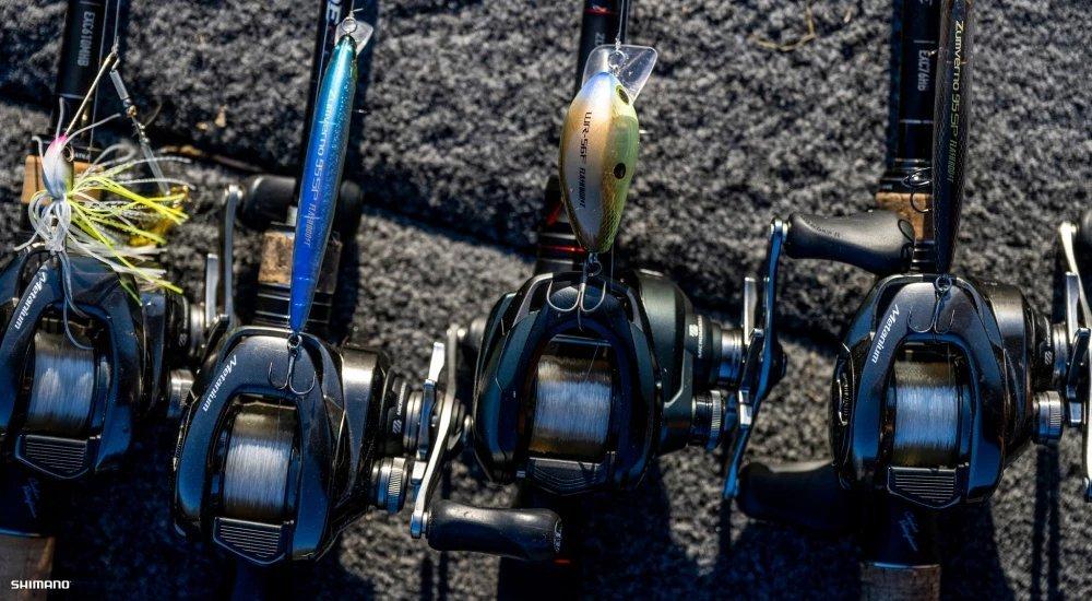 several shimano baitcast reels in a row on a boat
