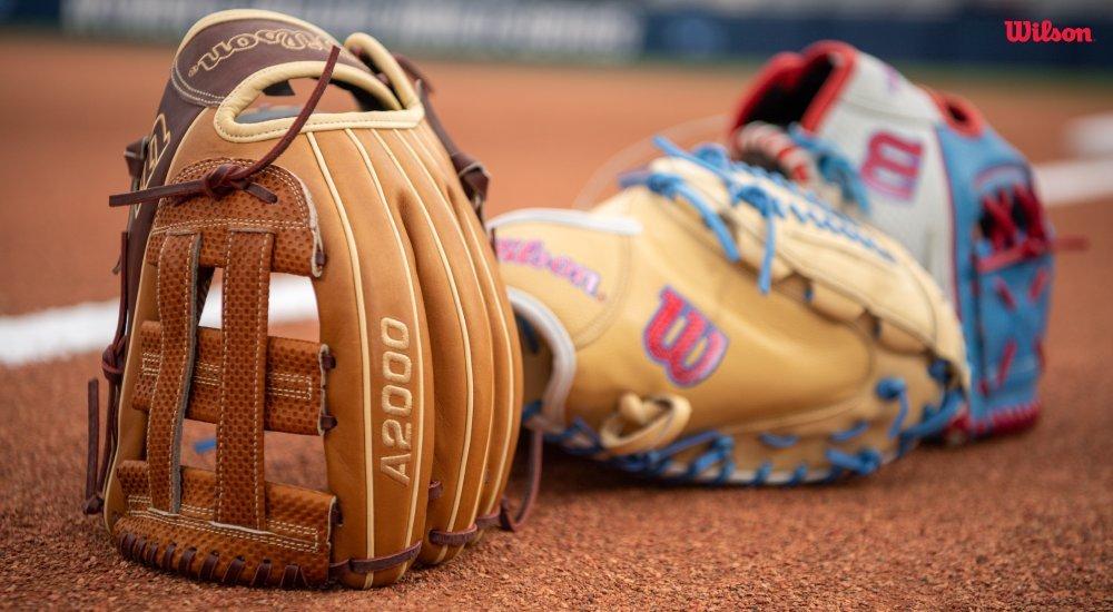 A lineup of Wilson baseball gloves on the diamond