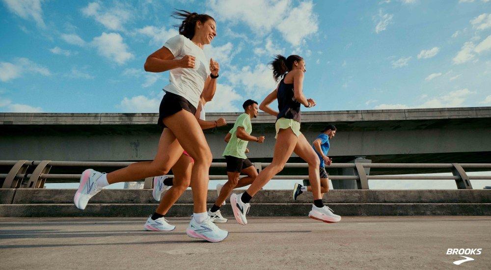 a group of runners on a road in Brooks running shoes