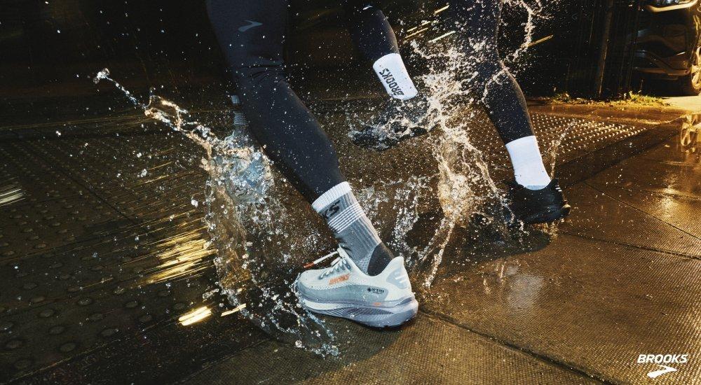 Two runners splashing through puddles