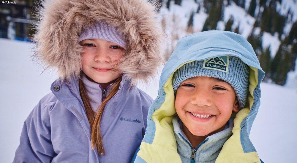 two kids wearing columbia outerwear coats in the snow