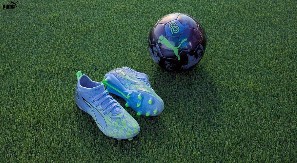 a pair of kids cleats and a soccer ball on the field