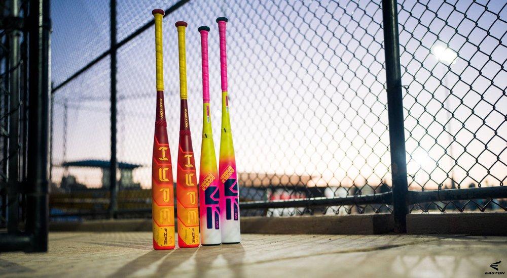 several baseball bats lined up along the fence