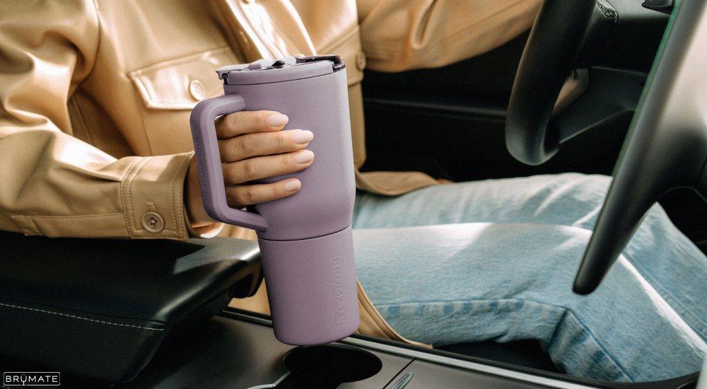 a woman holding her water bottle while driving