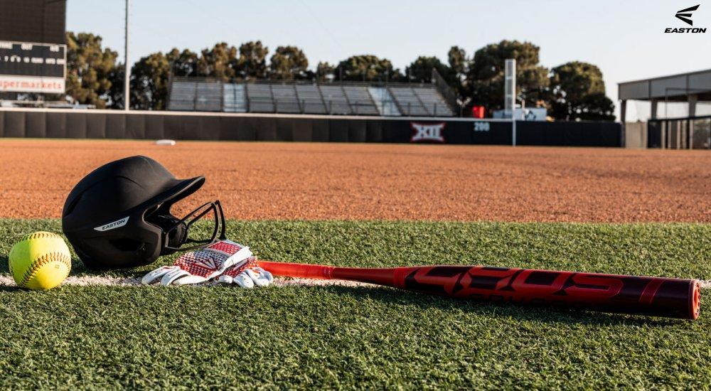 softballs and softball bats sitting on the grass