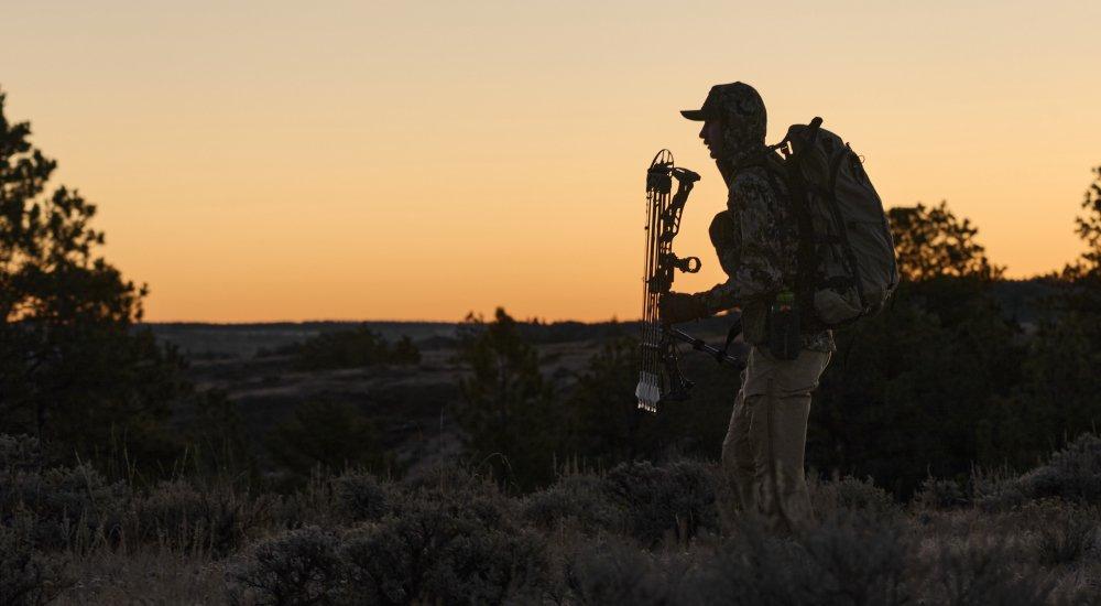 closeup of a hunter holding a compound crossbow