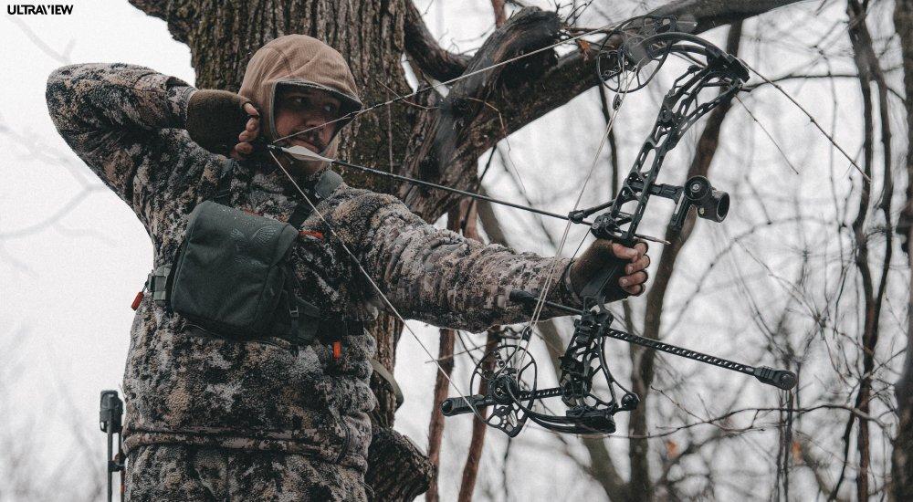an archer pulling back a compound bow with a release