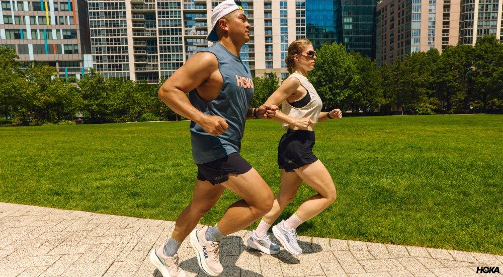 two people running outdoors in shorts and tank tops in the summer