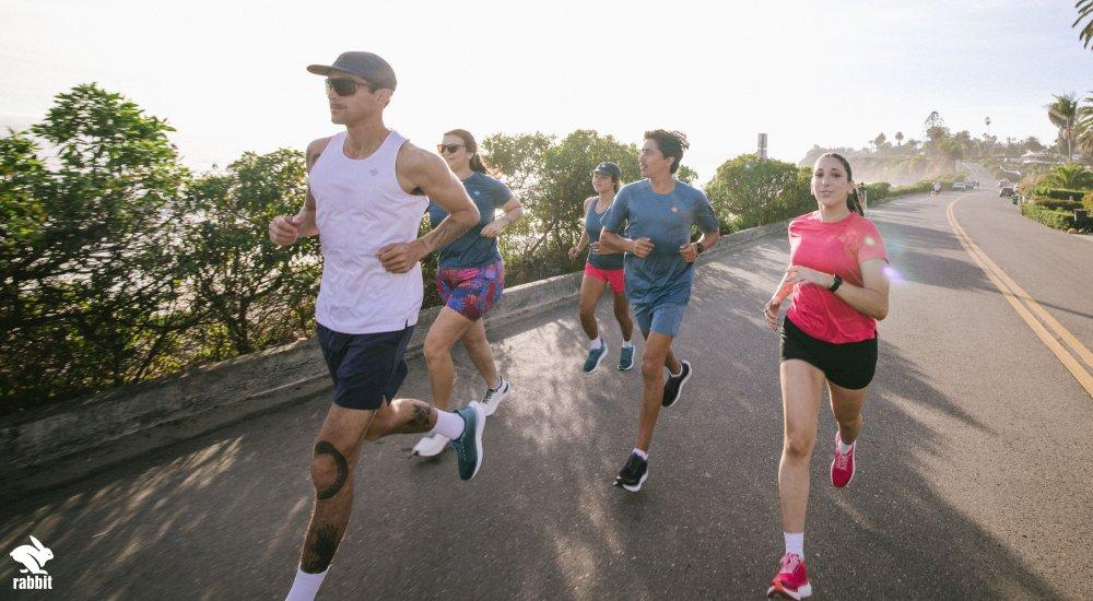 a group of people running in the summer in rabbit running clothing