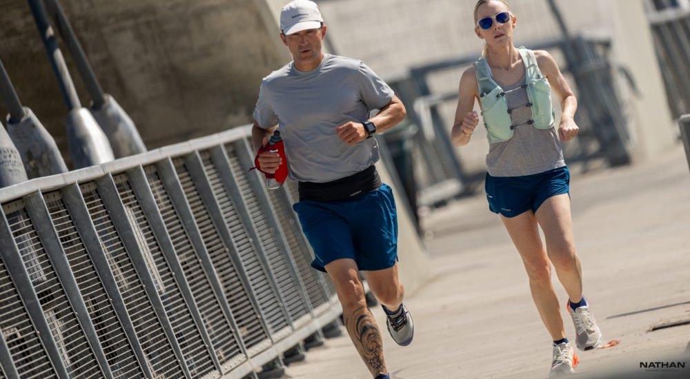 two people running outside while carrying water